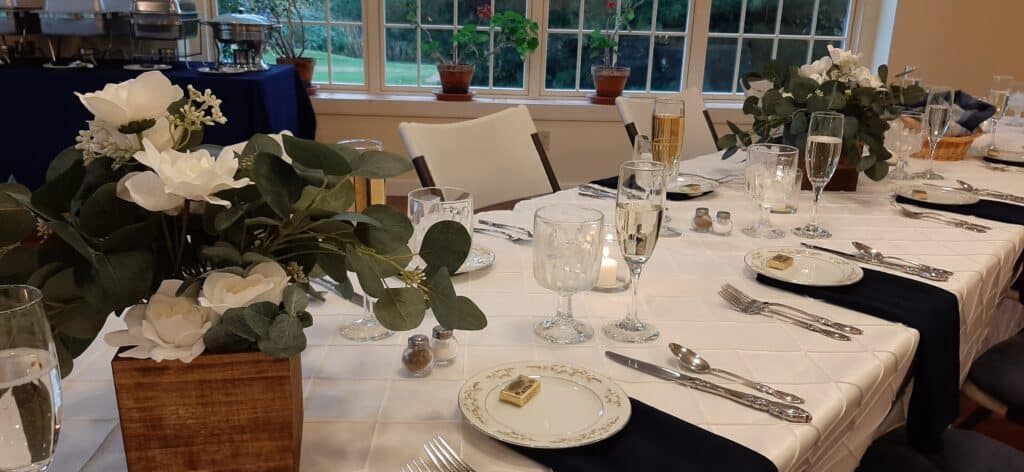 Dining Table set up for wedding with white floral centerpieces and champagne