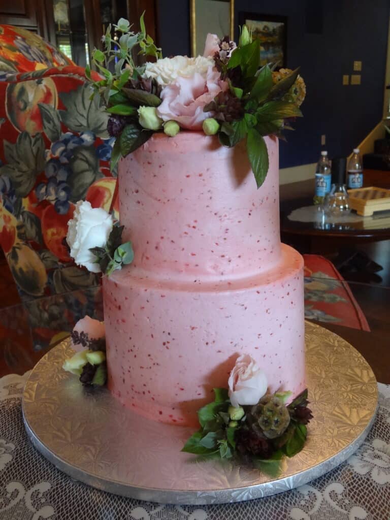 Pink, two tiered wedding cake with flowers