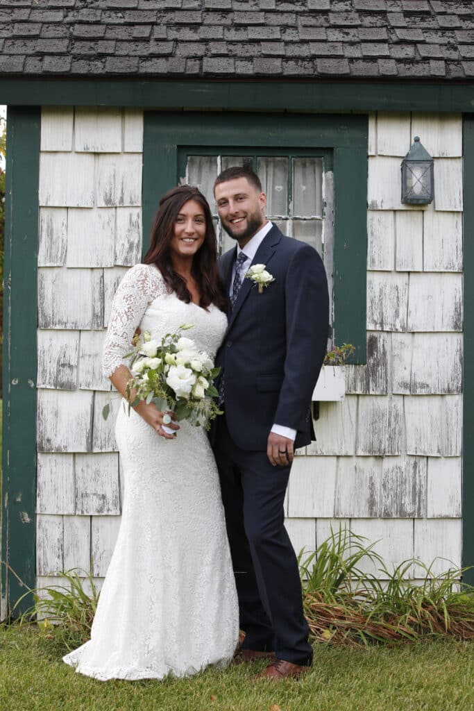 Bride & Groom in front of a white and green building