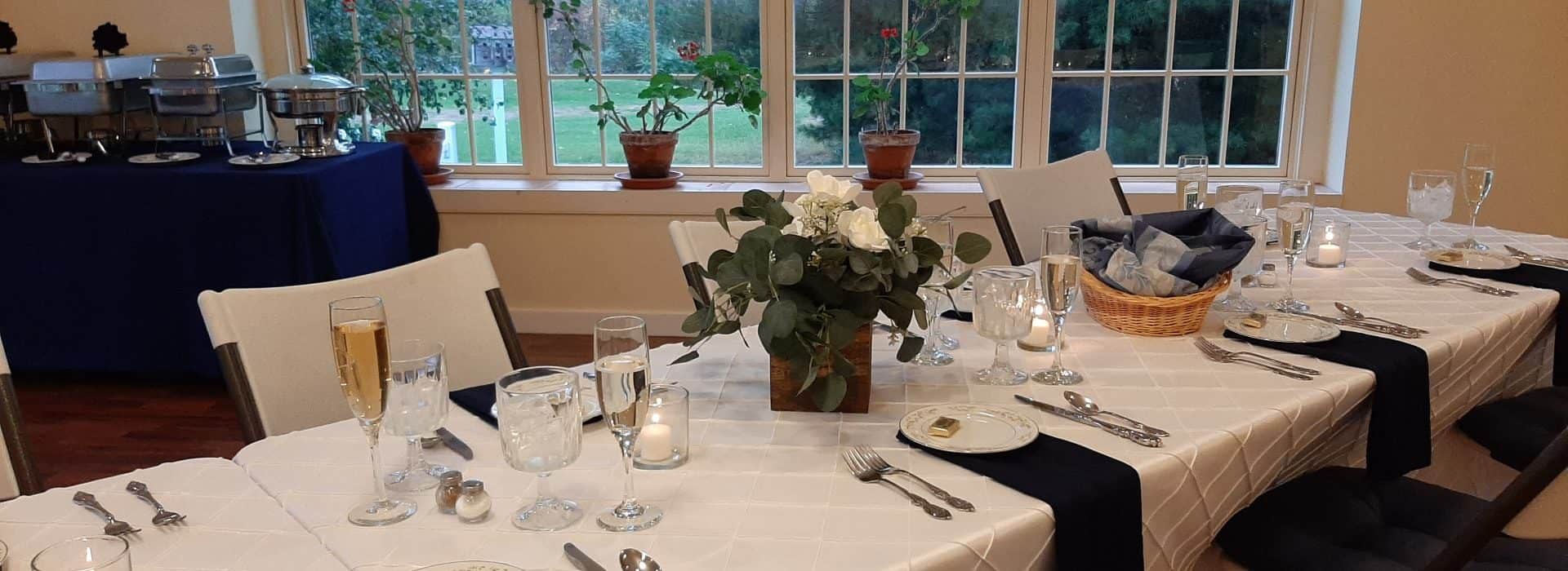 Reception buffet with white and midnight blue cloths, silver cutlery and crystal glassware.