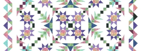 A Walk in the Park Quilt in purples, greens, and blues on a white background